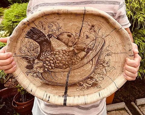 Finished oak plate with game-bird engraving and natural cracks